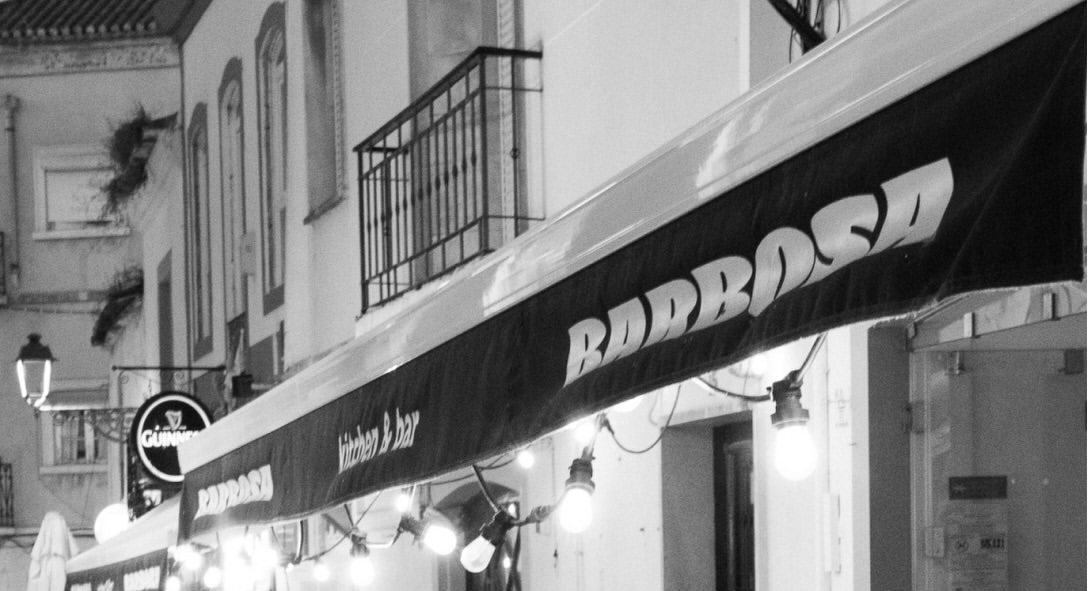 Toldo do BARBOSA numa rua do centro histórico de Lagos, em preto e branco